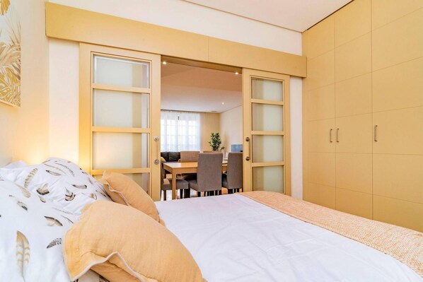 A bedroom with a bed, a desk, and a chair.