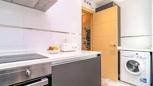 A modern kitchen with a built-in oven, a dishwasher, and a washing machine.