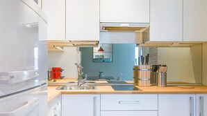 Eine moderne Küche mit weißen Schränken, Edelstahlgeräten und einer Holz Arbeitsplatte.