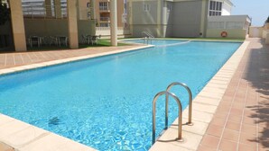 A swimming pool with a tiled deck, metal handrails, and a lifebuoy. - Apartamento Luise Para 4 Personas (Calpe)