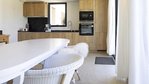 A modern kitchen with wooden cabinets, a white countertop, a microwave, and an oven. - Villa Tica in Malauc ne (Malaucene)