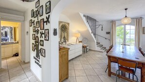 Une cuisine spacieuse avec un coin repas, un escalier et une grande fenêtre.