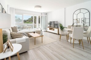 Un salon moderne avec un canapé, une table basse et un coin repas.