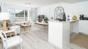 A modern living room with a sofa, chairs, a coffee table, and a TV. - RI B2a- Relaxed Modern Flat in Benahavis (Benahavis)