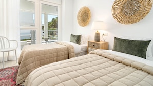 A hotel room with two beds, a window with a view, a lamp, and a decorative wall piece. - RI B2a- Relaxed Modern Flat in Benahavis (Benahavis)