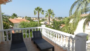 A balcony with two black lounge chairs and a white balustrade. - Villa Fig Tree Para 4 Personas (Calpe)