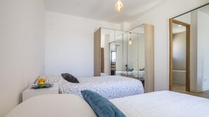 A modern bedroom with two beds, a large mirror, and a wardrobe. - Maison des Fleurs in Ved ne (Vedene)