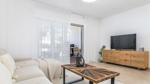 A modern living room with a sofa, a wooden coffee table, a TV, and a wooden cabinet. - Ags48b- Great Location Close to Puerto Banus Casa (Marbella)