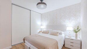 A bedroom with a bed, bedside tables, and a nightstand.