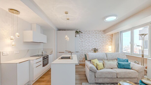 A modern kitchen with white cabinetry, a central island, and pendant lighting.
