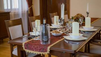 Una mesa de comedor dispuesta con platos blancos, vasos y un candelabro.
