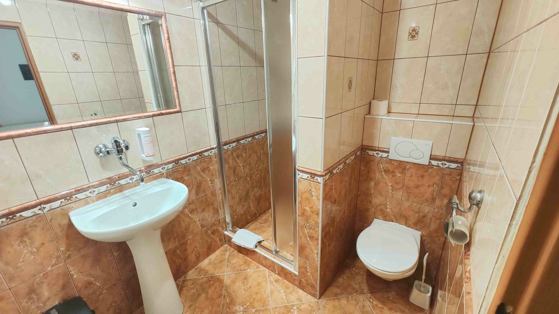 Un baño con lavamanos, inodoro y ducha.