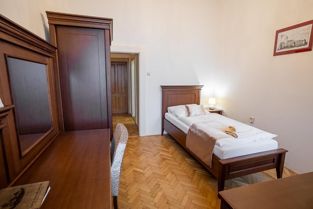Un dormitorio con una cama de madera, un escritorio y una silla.