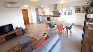 Een modern appartement met een zithoek, eetgedeelte en keuken.