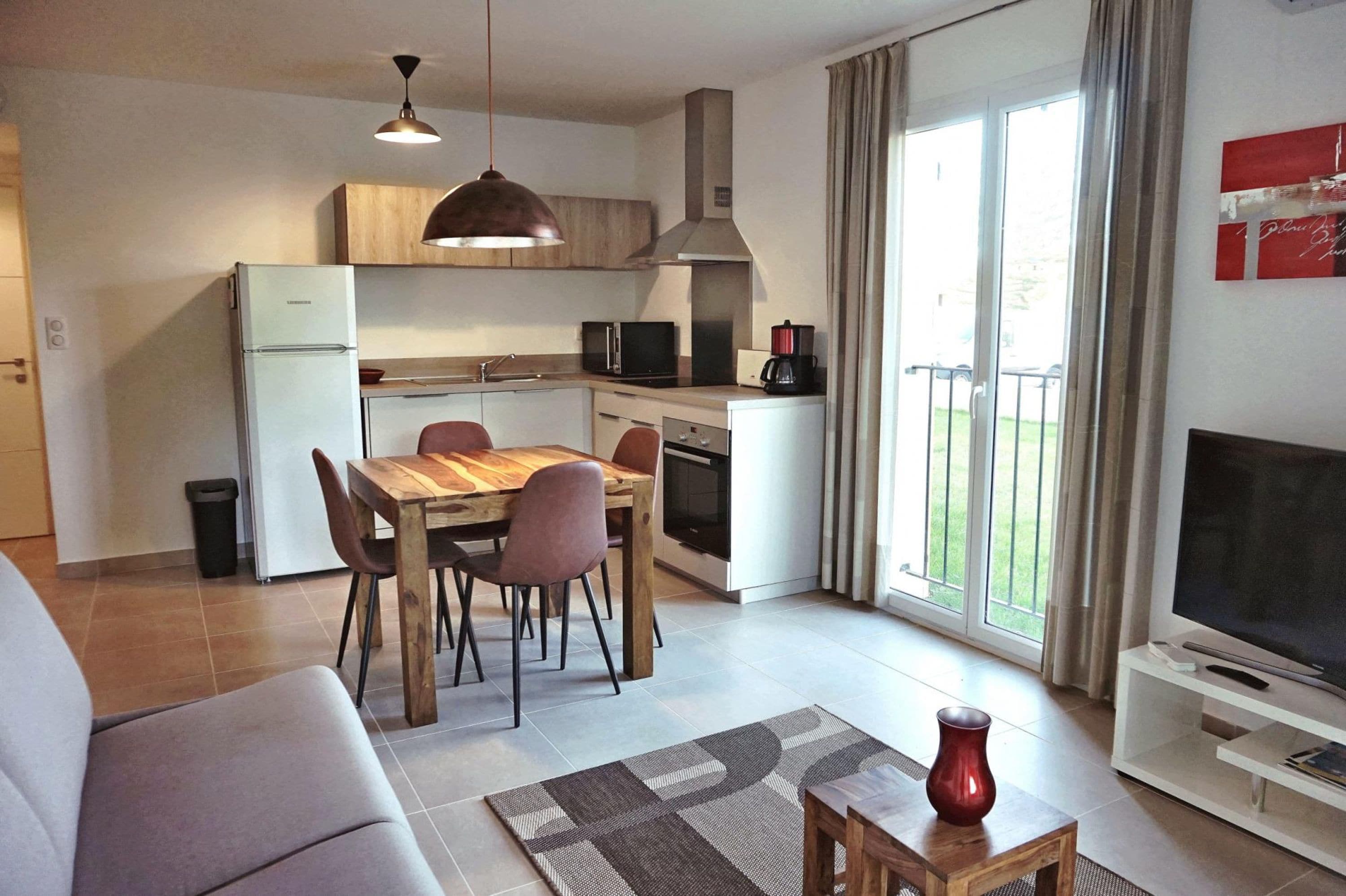 Un appartement moderne comprenant une cuisine, un coin repas et un salon.