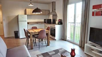 A modern apartment with a kitchen, dining area, and living room.
