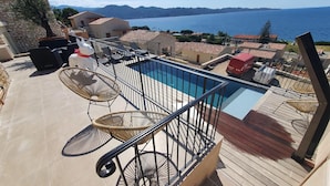 A rooftop pool area with a view of the sea and mountains. - Mor405 - T3 Neuf vue mer Panoramique Avec Piscine (Saint-Florent)