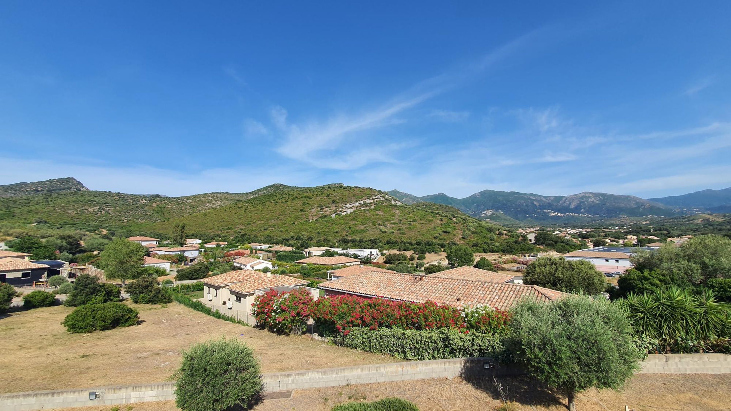 Zona residencial con casas, una colina y cielo despejado.