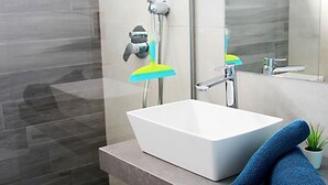 Une salle de bain moderne avec un lavabo blanc, un miroir et une fenêtre.