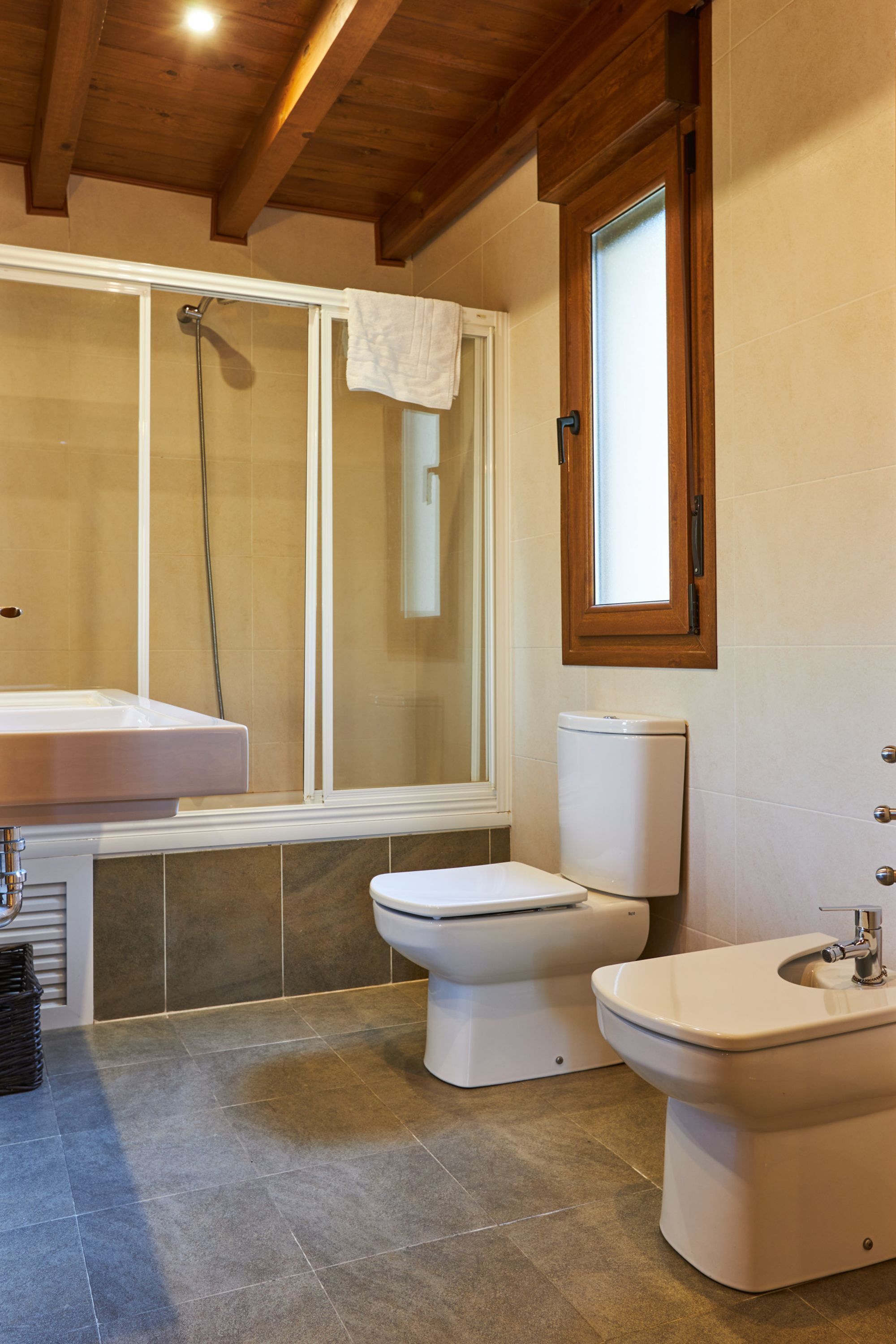 A bathroom with a shower, toilet, and sink.