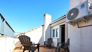 A rooftop terrace with a fan, chairs, and a window. - AV Soterra a 3B in Vila (Ávila)