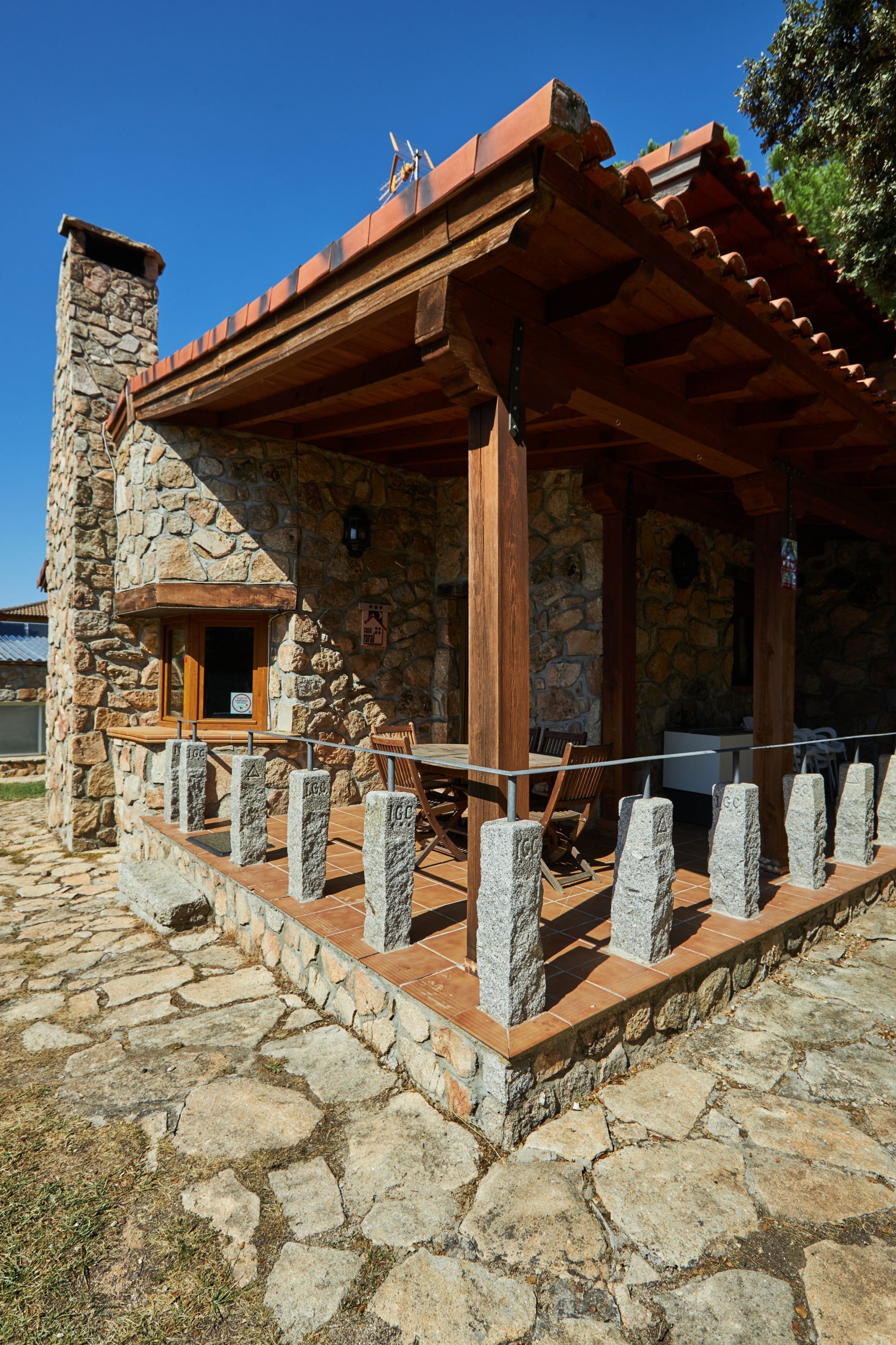 A stone building with a wooden porch and a stone chimney.