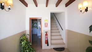 A staircase with a fire extinguisher and a sign indicating an exit. - Happy 2 - Estudio Vistas A Calle (Villajoyosa)