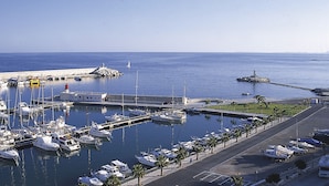 A marina with boats docked, a lighthouse, and a pier extending into the water. - Happy 2 - Estudio Vistas A Calle (Villajoyosa)