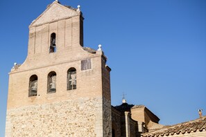 A historic church with a bell tower, stone walls, and a tiled roof.