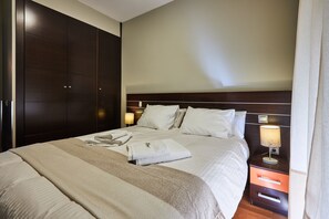 A hotel room with a large bed, a wardrobe, a bedside table with a lamp, and a nightstand. - AV Soterra a 1A in Vila (Ávila)