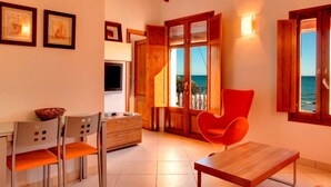 A cozy room with a wooden table, two chairs, a TV, and a window with a view of the sea. - Playa 2 - 1 Habitaci N Vistas AL MAR (Villajoyosa)