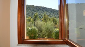 A window with a view of a lush garden and a hill. - Fta-bel01 APT 6 PAX Vicino AL Mare (Budoni)