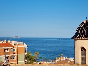 A coastal view with buildings, a clear blue sky, and the sea. - Plaza Iglesia - Apartamento CON Terraza (Villajoyosa)