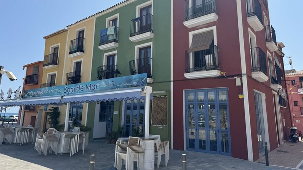 A colorful building with a storefront and outdoor seating area.