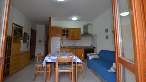 A compact living space with a kitchenette, dining area, and a sofa.
