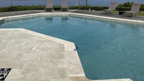 A swimming pool with lounge chairs and a view of the sea and mountains. - Villa d Exception vue mer Panoramique Piscine (Saint-Florent)