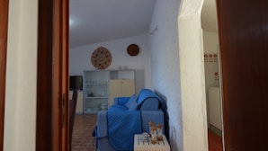 A compact living space with a sofa, a small table with a cup and saucer, and a cabinet in the background. - Fpo-rose02p1 in Ottiolu (Budoni)
