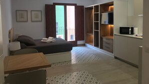 Una camera da letto con un letto, un comodino, una scrivania, una sedia, un armadio e un televisore.