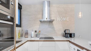 A modern kitchen with a built-in oven, microwave, and washing machine. - Casa Nicola in Guardamar (Guardamar del Segura)