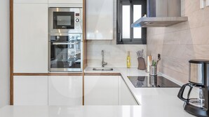 A modern kitchen with stainless steel appliances, a built-in oven, microwave, and a coffee maker. - Casa Nicola in Guardamar (Guardamar del Segura)