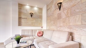 A modern living room with a beige sectional sofa, a glass coffee table, and a potted plant. - Retreat w Ocean Views Private Parking Ensuite (Los Realejos)