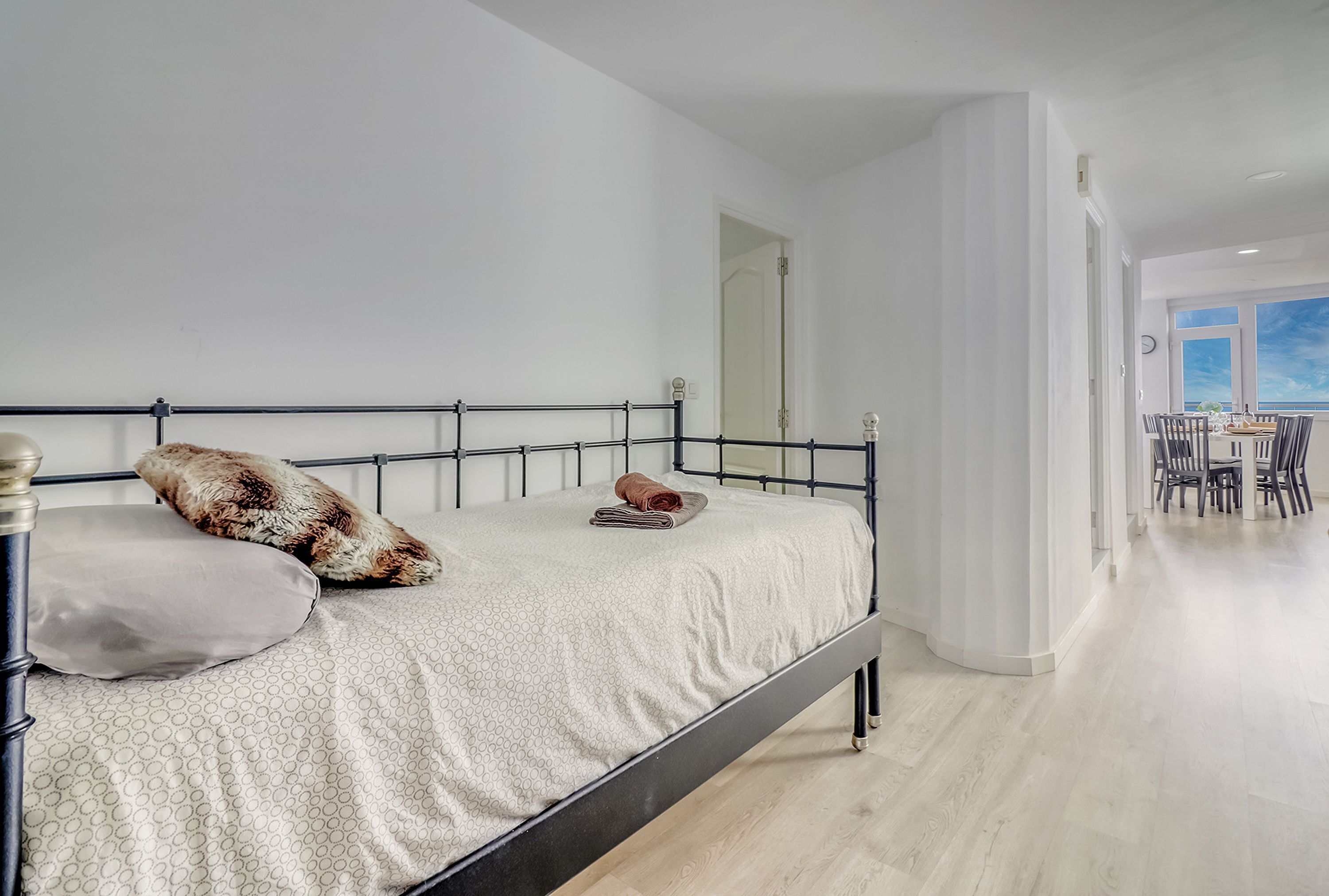 A bedroom with a bed, a pillow, and a folded towel.