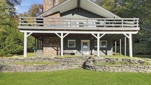 Ein zweistöckiges Haus mit Balkon, Stein Fundament und Schornstein.
