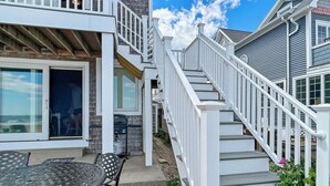 A residential property with a covered patio, outdoor seating, and a staircase leading to the upper level. - Sandcastle - W148 in Wells (Wells)