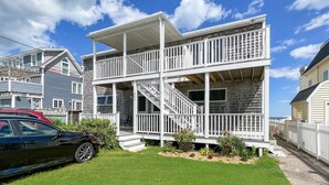 A two-story house with a covered porch and a staircase leading to the upper level. - Sandcastle - W148 in Wells (Wells)