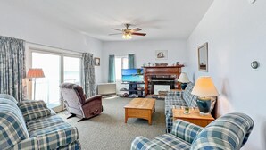 A living room with a fireplace, a television, and a ceiling fan. - Sandcastle - W148 in Wells (Wells)