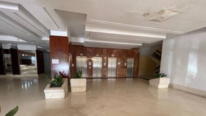 A spacious lobby with a marble floor, wooden paneling, and three elevators. - Tina de Steram Flats Torremolinos (Torremolinos)