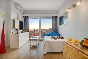 A hotel room with a balcony, a bed, a desk, and a small table. - Solpor de Steram Flats Benalmadena (Benalmádena)