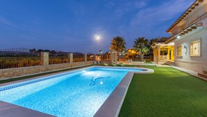A swimming pool with a tiled edge, surrounded by a well-maintained lawn and a stone wall. - Real Dream Villa by Fidalsa (Jacarilla)