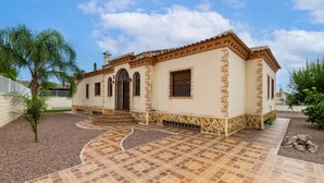 A house with a tiled patio, a small garden, and a palm tree. - Mountain Beautiful by Fidalsa (Busot)